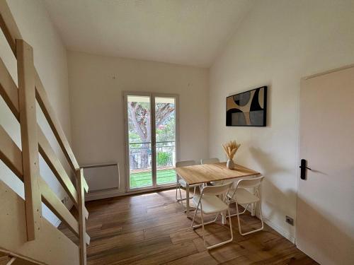 une salle à manger avec une table et des chaises et un escalier dans l'établissement Appartement T3 mezzanine, plage des Sablettes à 300 m !, à La Seyne-sur-Mer