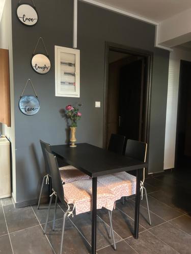 a dining room with a black table and chairs at ANGEL home in Kostakioí