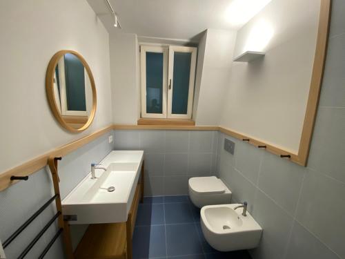 a bathroom with a sink and a toilet and a mirror at Alessandra House in Grottammare