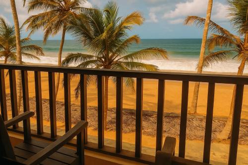 a view of a beach with palm trees and the ocean at Hôtel Restaurant Lounge Madiana Plage in Grand-Bassam