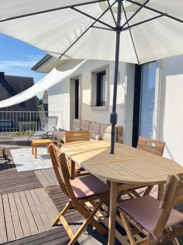 - une table et des chaises en bois avec un parasol sur la terrasse dans l'établissement BONNE IDEE - Suite GEORGETTE - Meublé de tourisme 3 étoiles, à Châtenois