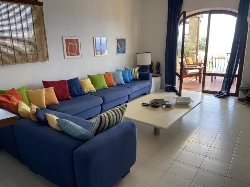 - un salon avec un canapé bleu et des oreillers colorés dans l'établissement Villa Shasa, à Talamone
