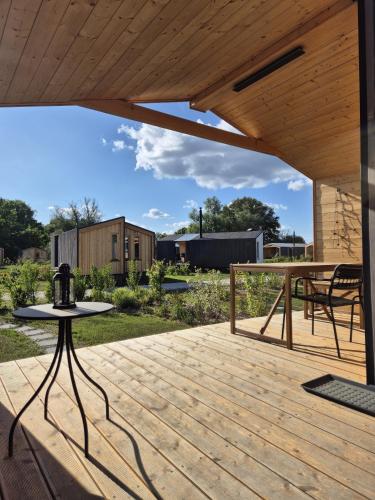 a patio with a wooden deck with a table at 309-Tiny House Main in Bleckede