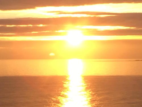 a sunset over the ocean with the sun in the sky at Ocean View at Kenwyn in Torpoint