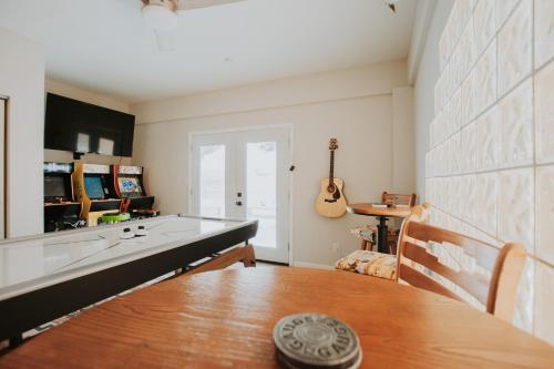 a living room with a table and a guitar at Cowboy Den-Hot Tub-Game Room-Pet Friendly-No Pet Fees! in Albuquerque