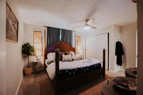 a bedroom with a large bed with a wooden headboard at Cowboy Den-Hot Tub-Game Room-Pet Friendly-No Pet Fees! in Albuquerque