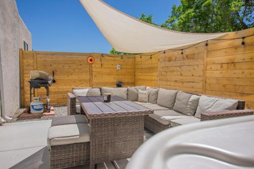 a patio with a couch and a table and a fence at Cowboy Den-Hot Tub-Game Room-Pet Friendly-No Pet Fees! in Albuquerque