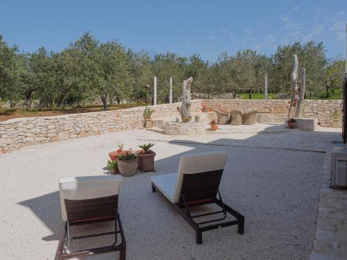 two chairs and a table in a courtyard at Casa Pietra Bianca Fay in Castellana Grotte