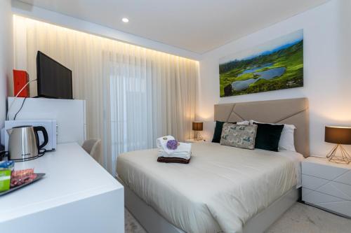 a bedroom with two beds and a television in it at GuestReady - Passal Guesthouse in Ponta Delgada
