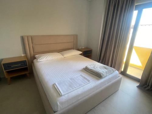 a small bedroom with a bed with a window at Luxury Rooftop Vlora in Vlorë