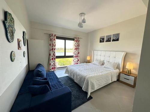 a bedroom with a bed and a couch and a window at Apartment at Marassi in El Alamein