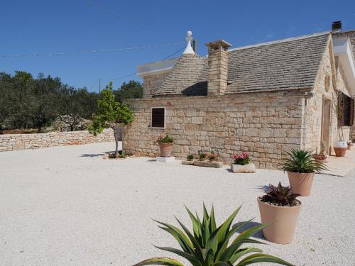 a stone building with potted plants in front of it at Casa Pietra Bianca Fay in Castellana Grotte