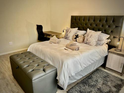 a bedroom with a large bed with a leather headboard at Sandy Greens Villa in Swakopmund