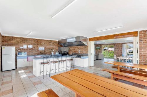 a kitchen with wooden counter tops and a brick wall at Moruya Holiday Park in Moruya