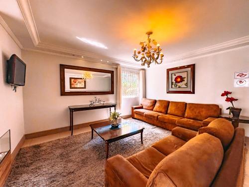 a living room with a couch and a table at VELINN Pousada Chateau do Luar Prime in Campos do Jordão