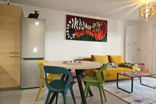 - un salon avec une table et des chaises colorées dans l'établissement L'Artistic centre du Chable près de Geneve, à Beaumont