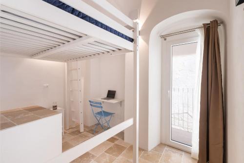 Una habitación con una escalera con un escritorio y una ventana. en Villa Helena by BarbarHouse, en Vieste