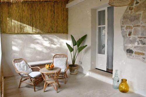 a patio with a table and chairs and a window at Giallo Limone in Teulada