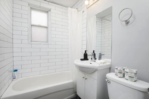 Un baño blanco con lavabo e inodoro. en Awesome 2BR in Montreal, en Montreal