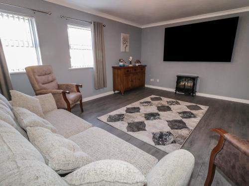 a living room with a couch and a flat screen tv at Shalom Apartment 100A in Armagh