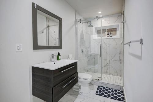 um banheiro com chuveiro, pia e vaso sanitário em The NDG Nest A Relaxing 3BR Getaway in DT MTL em Montréal