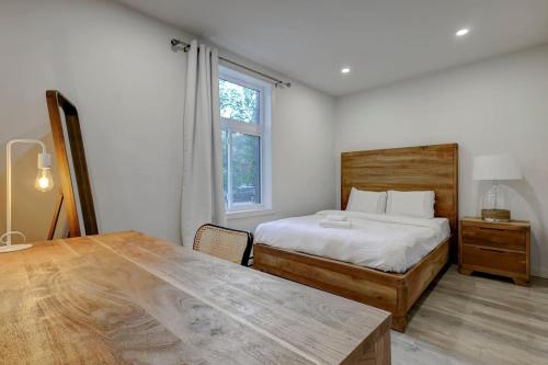 a bedroom with a bed and a table and a window at The NDG Escape Prime Location and Cozy Stay in Montréal