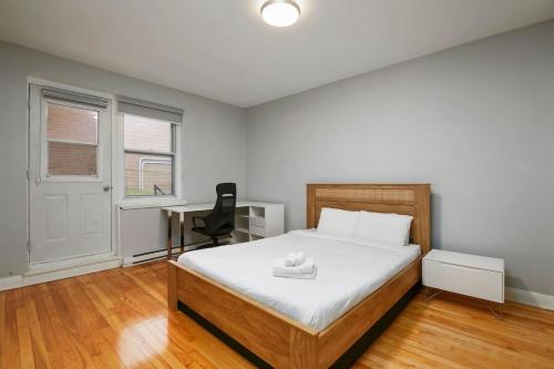 Un dormitorio con una cama con un escritorio y una silla. en Stylish 2BR in Montreal, en Montreal