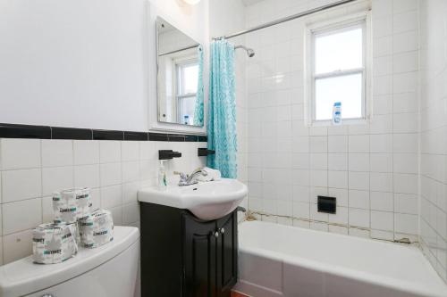 a white bathroom with a sink and a bath tub at Beautiful 2BR on Walkley in Montréal