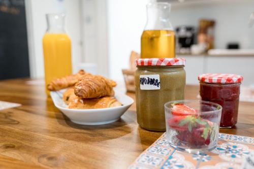 a table with a plate of pastries and a bowl of fruit at Ted Surf House in Capbreton