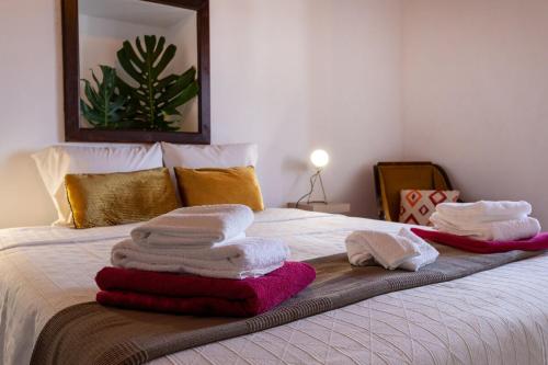 a bed with towels sitting on top of it at GuestReady - Casa dos Moinhos near the beach in Porto Formoso