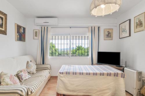 a living room with a couch and a tv at Villa Rosario in El Bosque