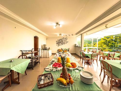 a dining room with a table with fruit on it at VELINN Pousada Chateau do Luar Prime in Campos do Jordão