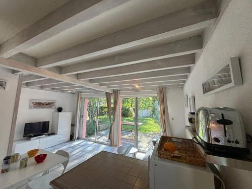une cuisine et un salon avec une grande fenêtre dans l'établissement Maison mitoyenne en duplex avec jardin proche lac, à Biscarrosse