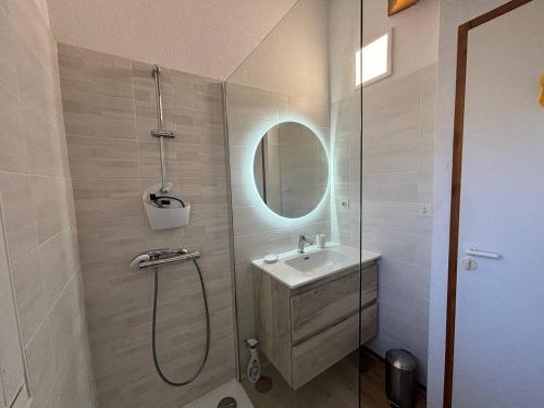une salle de bain avec une douche, un lavabo et un miroir dans l'établissement Maison mitoyenne en duplex avec jardin proche lac, à Biscarrosse