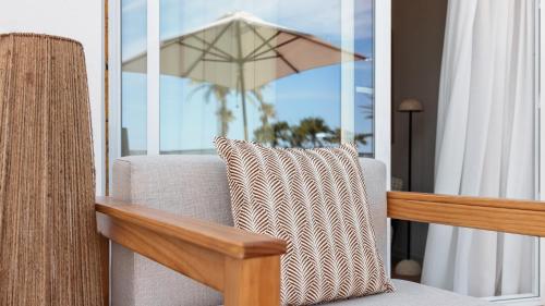 a living room with a chair and an umbrella at Hotel Indigo Gandia Beach by IHG in Gandía