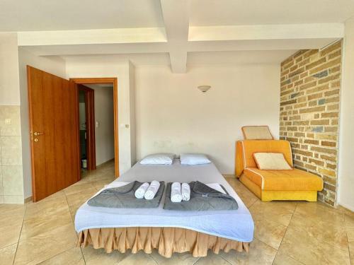 a bedroom with a bed and an orange chair at Contessa Apartments in Budva