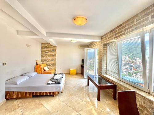 a bedroom with a bed and a brick wall at Contessa Apartments in Budva
