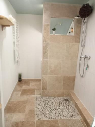 a bathroom with a shower with a tiled floor at Appartement au rez-de-chaussée in Souillac