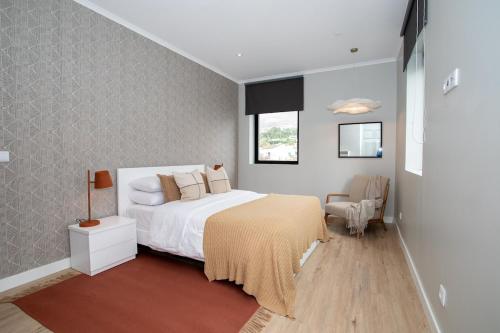 a bedroom with a white bed and a window at Casa do Gaveto in Água de Pau