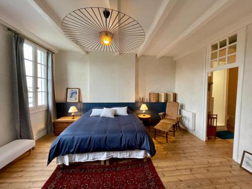 - une chambre avec un lit bleu, une table et des chaises dans l'établissement Gîte La Bergeronnette, à Saint-Savinien