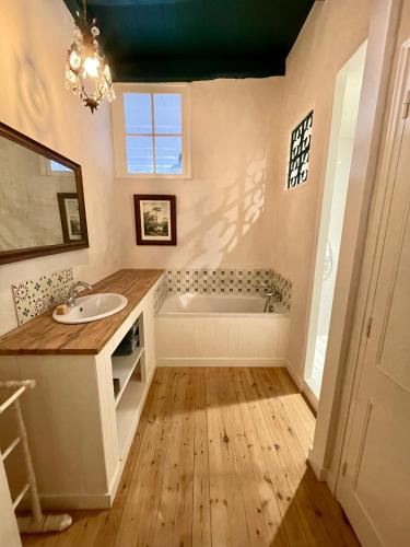 une salle de bain avec un lavabo et une baignoire dans l'établissement Gîte La Bergeronnette, à Saint-Savinien
