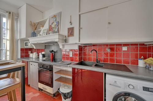 une cuisine avec des placards blancs et du carrelage rouge dans l'établissement HenRi - 5 minutes de la Gare à pied - Climatisation - Wi Fi, à Avignon
