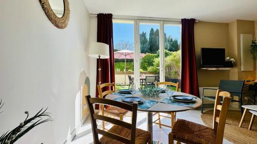 une salle à manger avec une table et des chaises et une fenêtre dans l'établissement Charme & Soleil YourHostHelper, à Castelnau-le-Lez