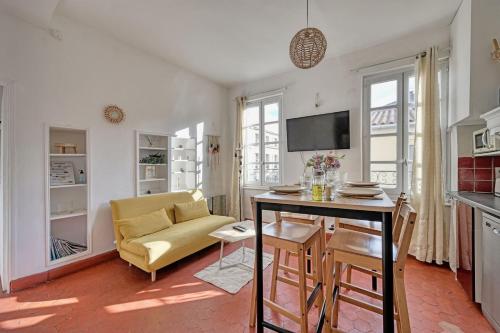 un salon avec un canapé jaune et une table dans l'établissement HenRi - 5 minutes de la Gare à pied - Climatisation - Wi Fi, à Avignon