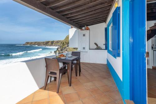 a patio with a table and chairs and the ocean at GuestReady - Beachfront Casa da Praia in Porto Formoso