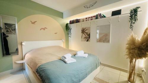 une chambre avec un lit avec deux serviettes dessus dans l'établissement Charme & Soleil YourHostHelper, à Castelnau-le-Lez