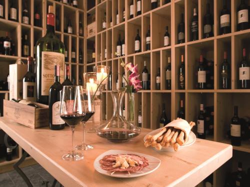 a table with a plate of food and wine glasses at Villa Favorita - Parkhotel Delta in Ascona