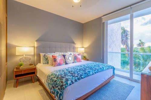 a bedroom with a bed and a large window at Oceanview Stay Pools Walk to Beach & Snorkel in Akumal