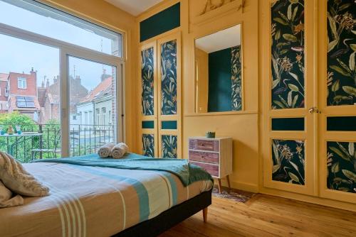 une chambre avec un lit et une grande fenêtre dans l'établissement Appart lumineux, 4P, balcon, proche marché, à Lille