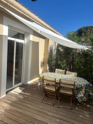 un patio avec une table et des chaises sur une terrasse dans l'établissement Le Nid Bleu, à Sanary-sur-Mer